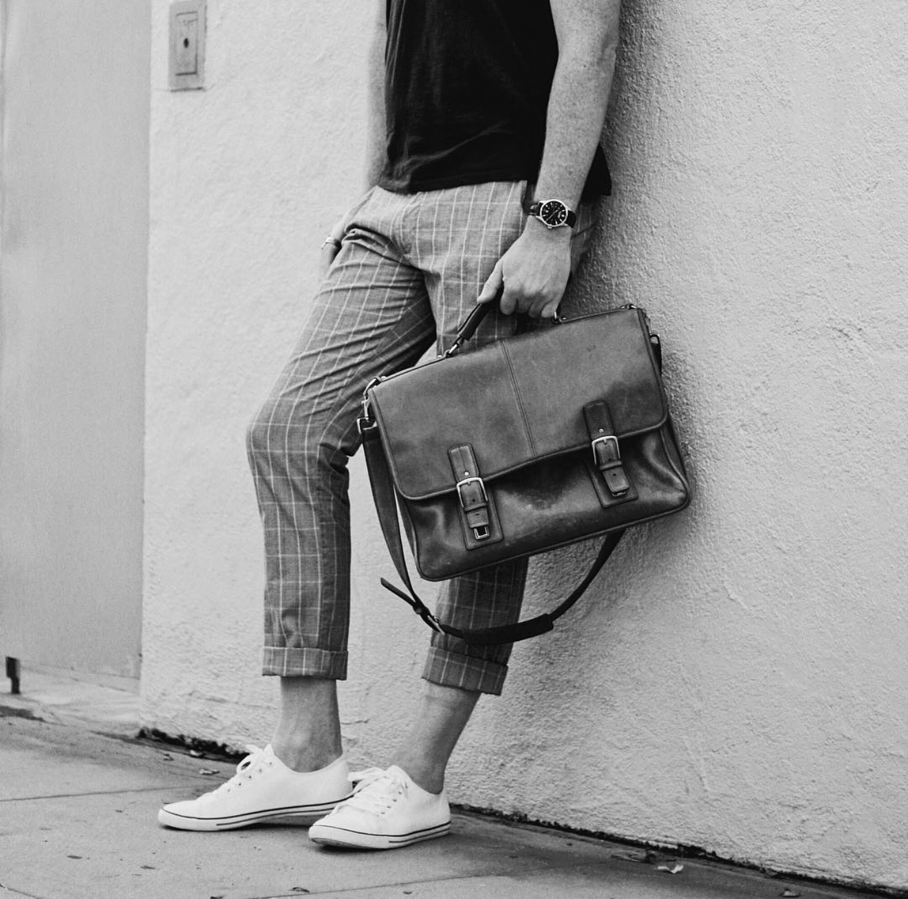 The founder of Friendship Cancelled holding a leather briefcase